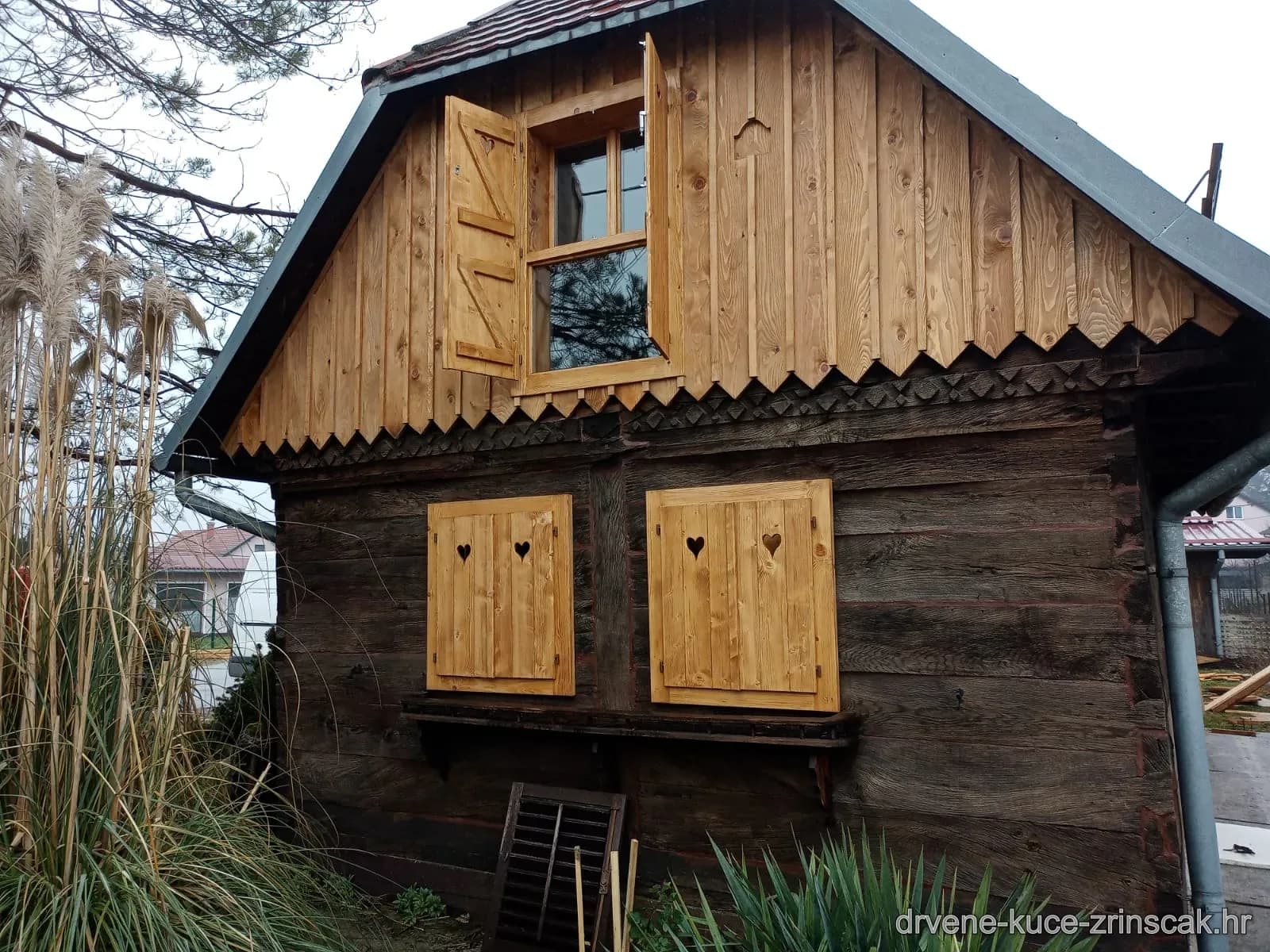 Drveni prozorski kapci s motivom srca na brvnari