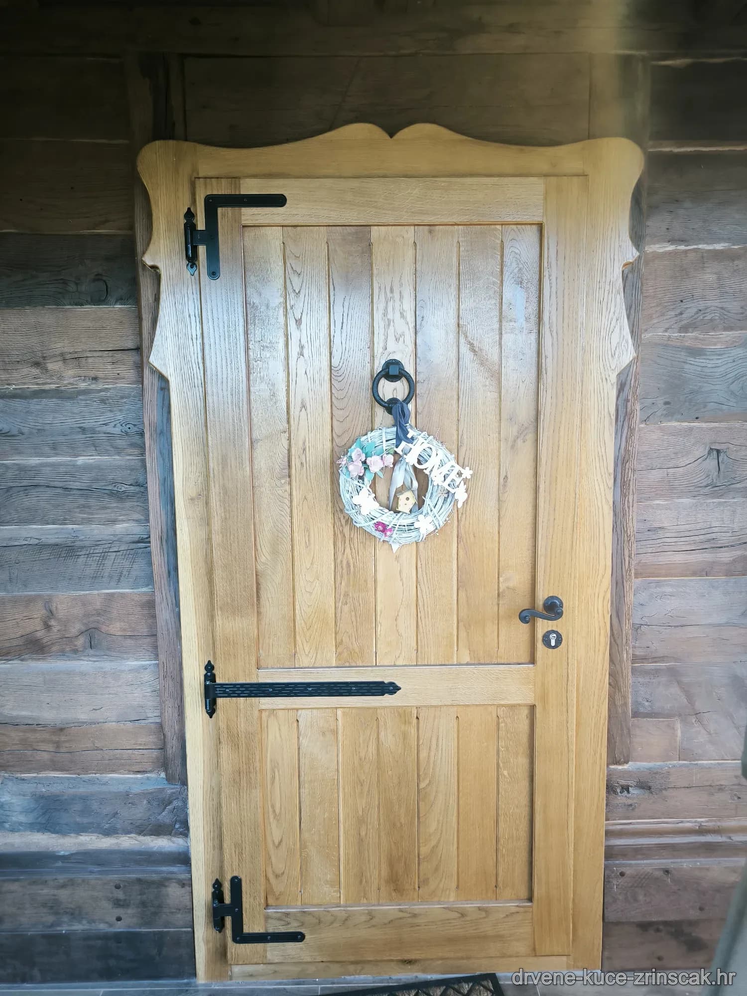 Rustikalna drvena vrata s vijencem i crnim šarkama